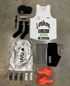 the contents of a running outfit laid out on top of a cement floor next to an orange shoe