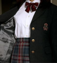 a woman wearing a skirt and jacket with a red bow tie