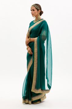 Emerald green saree in silk organza base with hand embroidered gota and marodi border. Paired with silk blouse and matching modal satin petticoat.
Components:3
Embroidered
Neckline:Round
Sleeve Length:Elbow
Fabric:Pure Silk Organza, Habutai Silk, Pure Modal Satin; Lining: Cotton
Color:Green
Placement back embroidered blouse
Concealed zipper closure blouse
Gota, mukaish and marodi work
Modal satin green petticoat - Aza Fashions Emerald Green Saree, Marodi Work, Gota Patti Saree, Organza Embroidery, Blouse Neck, Green Saree, Embroidered Neckline, Silk Organza, Saree With Blouse