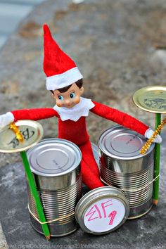 an elf is sitting on top of tin cans