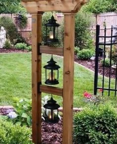 a wooden structure with lanterns hanging from it's sides in the middle of a garden