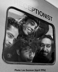 black and white photograph of group of people looking out the window on a subway train