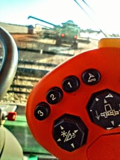 a close up view of a steering wheel and buttons on a game console controller, with a train in the background