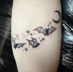 a black and white photo of bats flying in the sky with stars on their legs