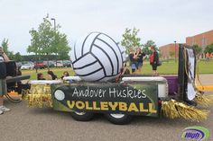 people are standing in the back of a truck with a volleyball on it's trailer