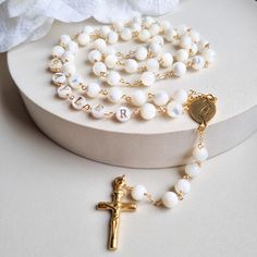 This Personalized Rosary, is ideal as a Baptism gift for a little girl or baby boy or as a gift for a special occasion. It is expertly handcrafted in a traditional style with a contemporary twist utilizing genuine Mother of pearl stone and gold-plated brass wire, which not only gives a touch of nature but also tenderness. The letter beads on the Rosary are also handmade from genuine mother of pearl, and the length is perfect to worn as a dainty Rosary necklace for women. MATCHING ROSARY BRACELET White Spiritual Cross Jewelry And Charms, Spiritual Letter Beads Necklace For Gift, White Spiritual Jewelry For Gifts, Handmade Rosary With Round Beads For Baptism, Handmade Adjustable Rosary For First Communion, Spiritual 8mm Beads Rosary For Baptism, White Necklace For First Communion And Mother's Day, White Cross Jewelry For Personalized Gift, White Cross-shaped Jewelry For Personalized Gift