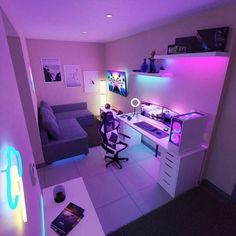 a room with a couch, computer desk and purple lighting