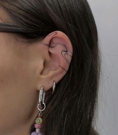 a close up of a person wearing some kind of earring with an elephant on it