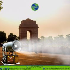 a water cannon spraying water on the ground in front of an arch with a clock