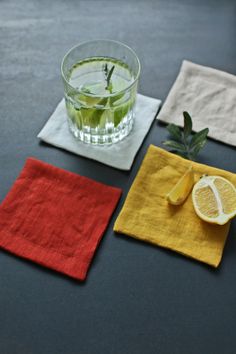 three napkins with lemon slices on them and a glass of water in the middle