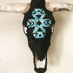 an animal's skull is decorated with blue and white beads on the antlers