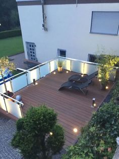 an outdoor deck with lights on the sides and plants growing in pots next to it