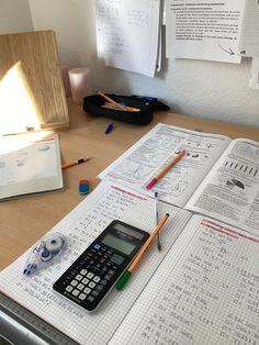 a calculator sitting on top of a desk next to an open notebook and pen