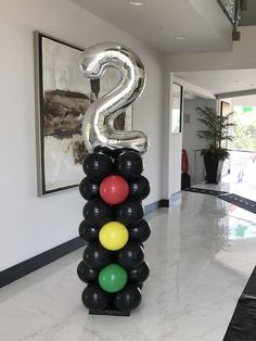 a balloon sculpture with the number 2 on top of it in front of a hallway