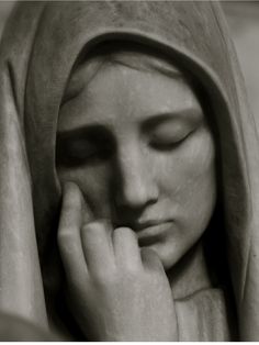 black and white photograph of a statue with her hands on her face