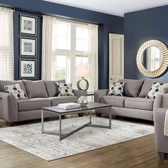 a living room with blue walls and white furniture in it, including two couches and a coffee table