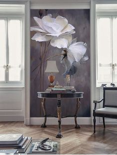 a room with a table, chair and flowers on the wall in front of it