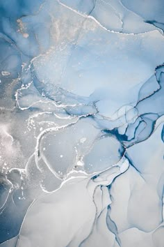 an aerial view of water and ice in the ocean, with blue hues on it