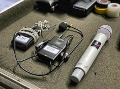 there are two microphones, an mp3 player and other electronic equipment on the table