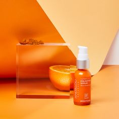 an orange sitting on top of a table next to a bottle of lotion and a bowl