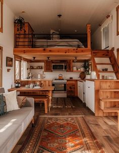 the interior of a tiny home with stairs leading up to the loft bed and kitchen