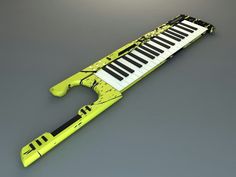 a yellow and black musical instrument sitting on top of a gray surface with the keys missing