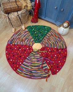 a multicolored rug on the floor in front of a blue cabinet and christmas tree