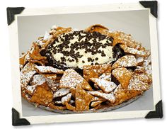 a pie with powdered sugar and chocolate toppings