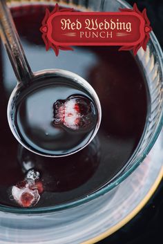 a spoon with some liquid in it on top of a glass bowl filled with ice