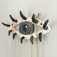 an eye sculpture hanging from the side of a wall