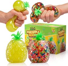 two hands are holding pineapples in front of a box of gummy bears