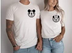 a man and woman standing next to each other wearing mickey mouse t - shirt designs