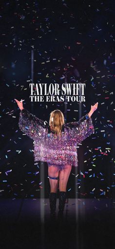 taylor swift performing on stage with confetti in the background