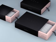 three black and pink boxes sitting next to each other on top of a blue surface