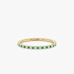 a gold band with emerald and white diamonds