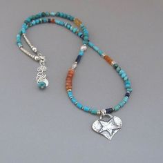 "Beautiful hand cut polished Turquoise with offset wheels of Carnelian and Citrine, polished midnight blue Lapis Lazuli and handmade silver beads surround a handmade sterling silver heart star charm. It closes with a lobster claw clasp, and an extender chain with a Turquoise dropping from the end of the chain. It is signed DJStrang. This necklace is made to order and will vary slightly from the photos. All metal is solid .970 fine silver and .925 sterling silver. Turquoise - approx.4mm Carnelian Beaded Neckless, 2024 Jewelry, Washer Jewelry, Necklaces Ideas, Boho Necklaces, Sundance Style, Boho Cowgirl, Diy Jewelry Necklace, Lapis Lazuli Necklace