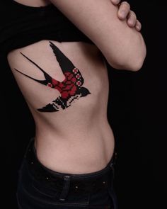 a woman's stomach with a bird tattoo on her side and the lower part of her body