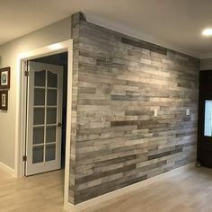 an empty room with wood paneling on the wall, and a flat screen tv