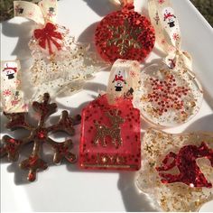 christmas ornaments are displayed on a white tray with red and gold sequinized decorations