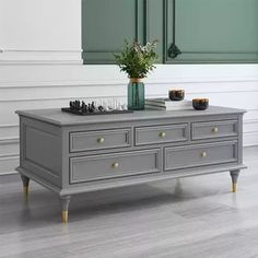 a grey dresser with two vases on top of it