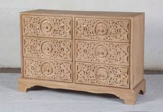 an ornate carved wooden cabinet with four drawers