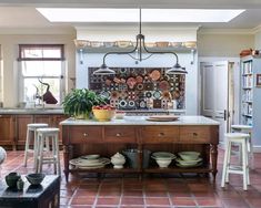 a kitchen with a center island and lots of plates on the counter top in front of it