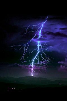 a lightning bolt is seen in the dark sky