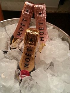 two champagne bottles sitting on top of ice