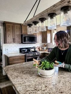 a woman sitting at a kitchen counter with a bowl of salad in front of her