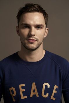 a man in a peace shirt poses for a photo