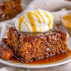 sticky toffe pudding on a white plate topped with whipped cream and caramel drizzle