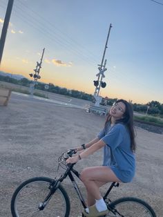 a woman is riding her bike in the middle of an empty lot with traffic lights