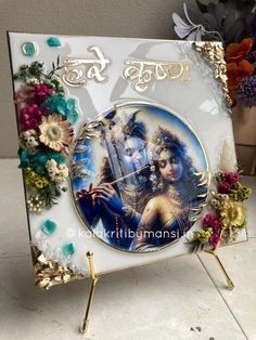 there is a clock decorated with flowers and an image of hindu god on the front