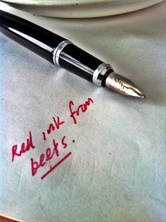 a pen sitting on top of a piece of paper that says red ink from beers